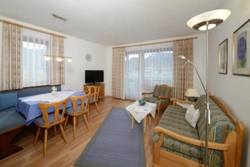 a living room with a couch and a dining room at Haus Vierjahreszeiten in Reit im Winkl