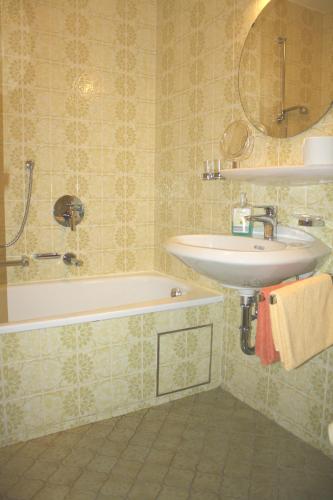 a bathroom with a sink and a bath tub at Haus Vierjahreszeiten in Reit im Winkl