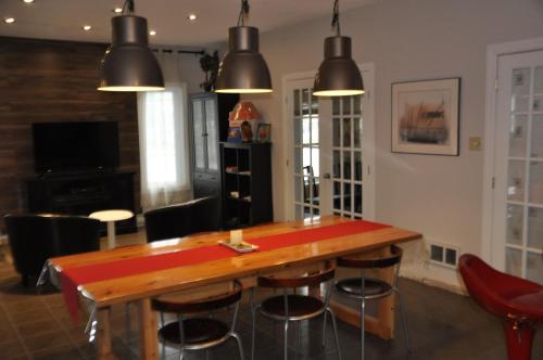 a dining room with a wooden table and chairs at Motel les Pignons Verts in Gatineau