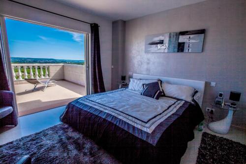 a bedroom with a bed and a large window at Château de valloubière-Gite in Saint-Jean-de-Fos