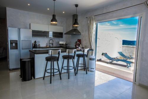 a kitchen with bar stools and a kitchen with a view at Château de valloubière-Gite in Saint-Jean-de-Fos