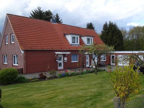 una casa con techo rojo y patio en Gesa Kronenberger, en Scharbeutz