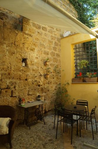 a room with tables and chairs and a brick wall at Khalisah in Palermo