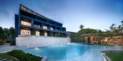 a swimming pool in front of a building at Navana Nature Escape - SHA Extra Plus in North Pattaya