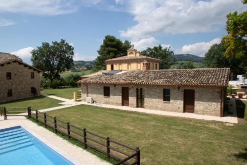 an old building with a pool in front of it at BorgoPratole CountryHouse in Cingoli