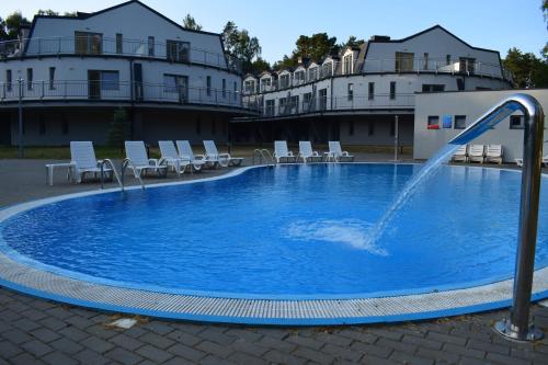 a swimming pool with a fountain in the middle at Apartamenty Silence Blue Baltic in Pobierowo