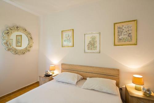 um quarto com uma cama branca e um espelho em Apartment Srdanovic em Budva