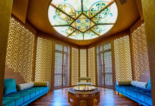 a living room with blue couches and a stained glass window at Crowne Plaza - Borjomi by IHG in Borjomi