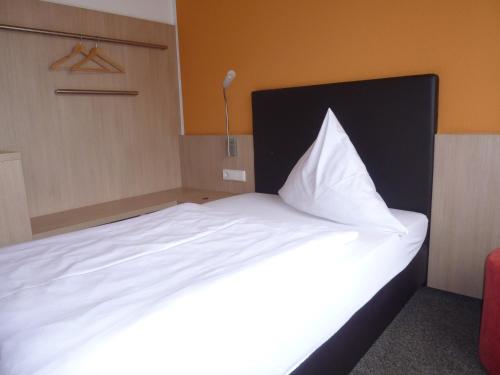 a bedroom with a large bed with white sheets at Gasthof zum Bad in Langenau