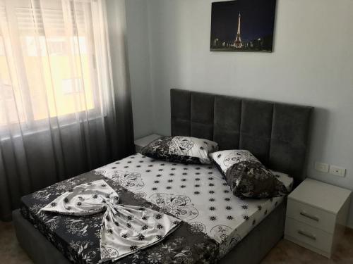 a bedroom with a bed with a black headboard and pillows at EKA Luxury One-Bedroom Apartment in Durrës