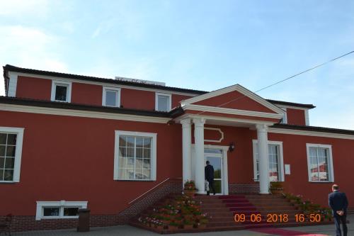 a man standing in the doorway of a red house at Hotelik Karter in Warsaw