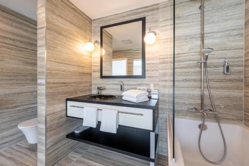 a bathroom with a sink and a shower at Trip Inn Conference Hotel & Suites in Wetzlar