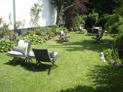 a group of chairs sitting on the grass in a yard at Hotel Sir & Lady Astor in Düsseldorf