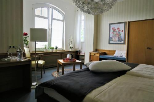 a bedroom with a large bed and a living room at Hotel-Restaurant Haus Keller in Laggenbeck