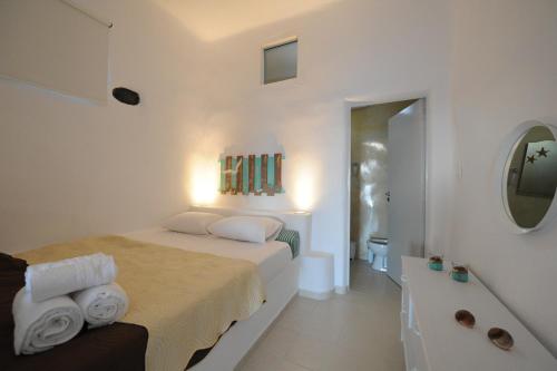 a white bedroom with a bed and a bath tub at Manias Fira Residences in Fira
