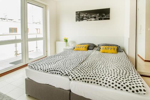 una camera bianca con un grande letto con cuscini gialli di Apartament Kniaziewicza - Komfortowe Noclegi a Piaseczno