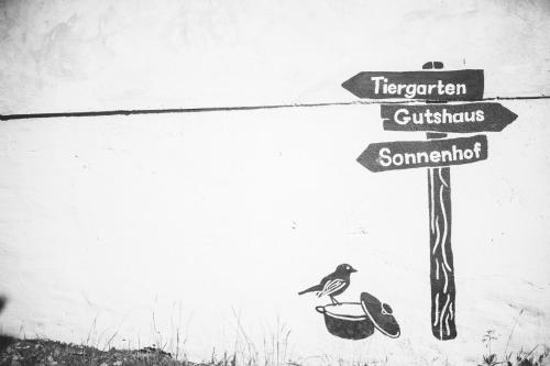 a street sign with a bird sitting in a basket at Gut Boltenhof in Fürstenberg-Havel