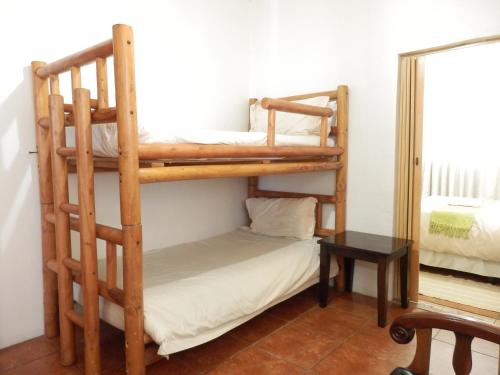 a bedroom with two bunk beds and a mirror at Oppi Rotse Guesthouse in St Lucia