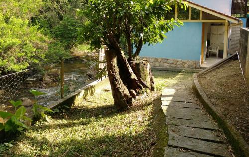 a house with a tree next to a river at Casa do Artista in Lumiar