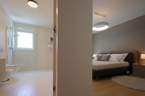 a bedroom with a bed and a bathroom at Designed Apartment with swimming pool near the beach in Opatija