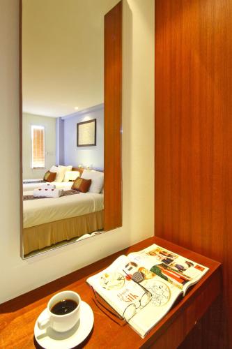 a bedroom with a mirror and a table with a cup of coffee at Floral Shire Suvarnabhumi Airport in Lat Krabang