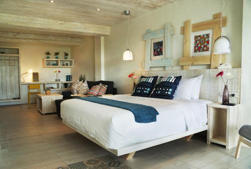 a bedroom with a large white bed with blue pillows at 湛藍海岸民宿 Azure-零泊預約居-這個夏天有點藍--墾丁南灣沙灘-可包棟-國旅卡 in Nanwan