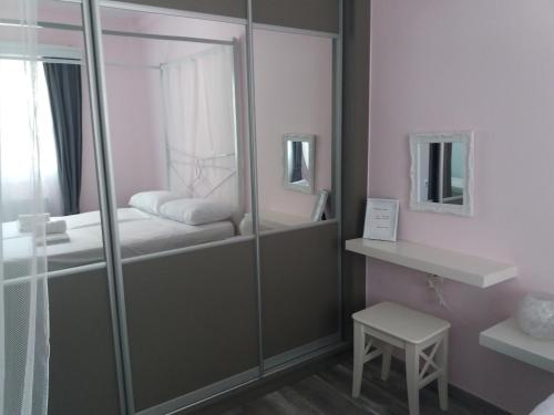 a small bathroom with a glass shower stall with a bed at "ΙωΚαρ" in Nafpaktos