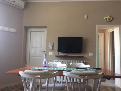 een eetkamer met een tafel met stoelen en een tv bij Villa L'Ottagono con cucina parcheggio privato telecamerizzato e wifi in Gioia del Colle