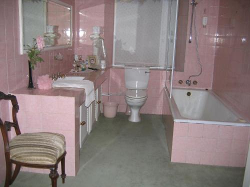 a pink bathroom with a tub and a sink and a toilet at Villa Victoria executive Guest House in Benoni