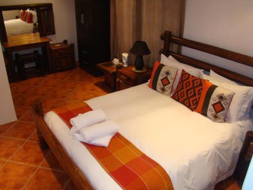 um quarto com uma cama grande e toalhas em Oppi Rotse Guesthouse em St. Lucia