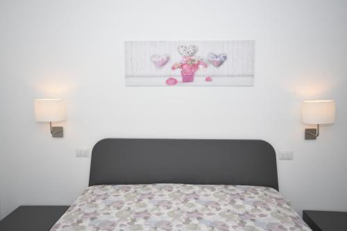 a bedroom with a bed with two lamps and a teddy bear at Sciabika Home - Edificio Eolie in Castellammare del Golfo