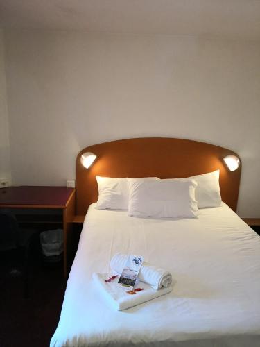 a bed in a hotel room with a book on it at Quick Palace St Jean De Vedas - A709 in Saint-Jean-de-Védas