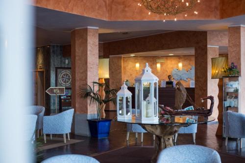 una hall con tavolo, sedie e lampadario pendente di TH Capoliveri - Grand Hotel Elba International a Capoliveri