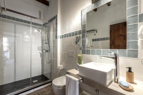 a bathroom with a toilet and a sink and a shower at Townhouse Can Butxaca By homevillas360 in Pollença