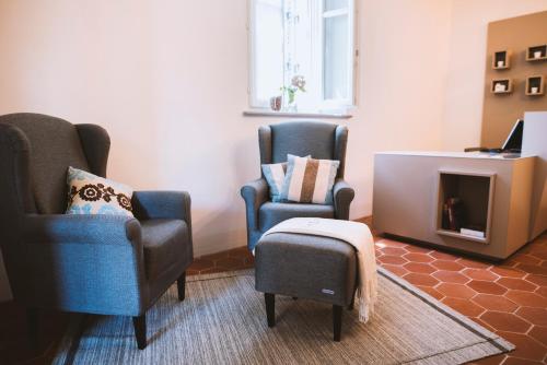 two chairs and a ottoman in a living room at Moonfrà in Antignano