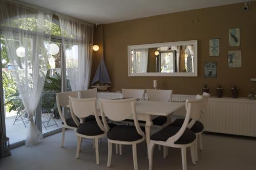 切什梅的住宿－薩赫勒碼頭公寓式酒店，一间配备有白色桌椅的用餐室