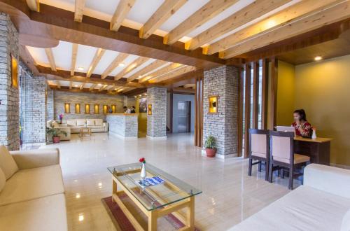 a woman sitting at a table in a lobby at Bodhi Suites Boutique Hotel and Spa in Pokhara