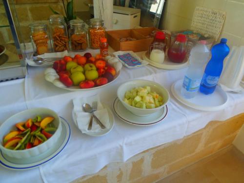 a table with bowls of fruits and vegetables on it at Missipezza Residence a Frassanito in Alimini