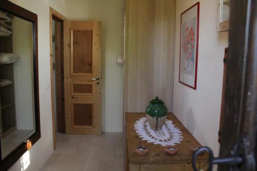 un corridoio con un tavolo e un vaso sopra di La Suite nel Bosco a Selva di Fasano