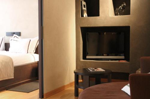 a bedroom with a bed and a tv and a mirror at Heritage Hotel Kukuriku in Kastav
