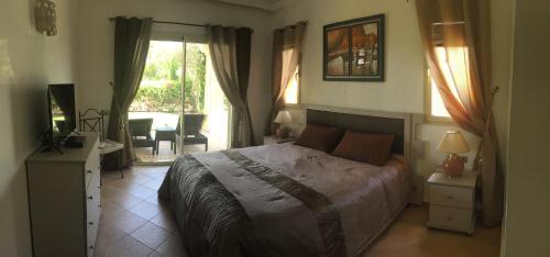 een slaapkamer met een bed en een kamer met een patio bij Résidence Naama in Agadir