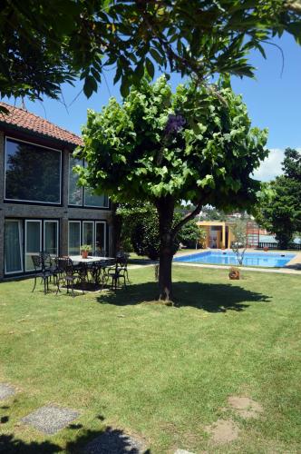 a yard with a table and a tree and a pool at Casa Do Carvalho in Viatodos