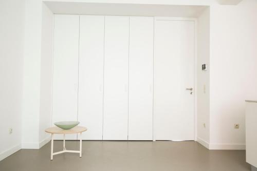 a room with a table and white wardrobes at The Meir Lodge. Apartments in heart of Antwerp in Antwerp