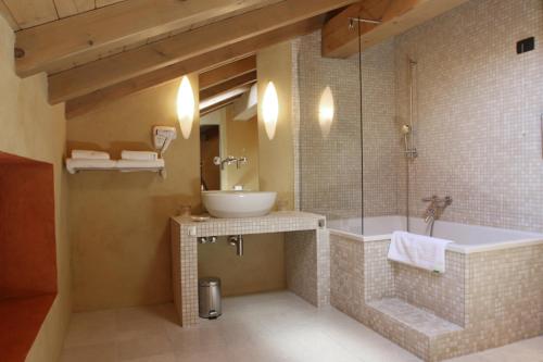 a bathroom with a tub and a sink and a shower at Heritage Hotel Kukuriku in Kastav