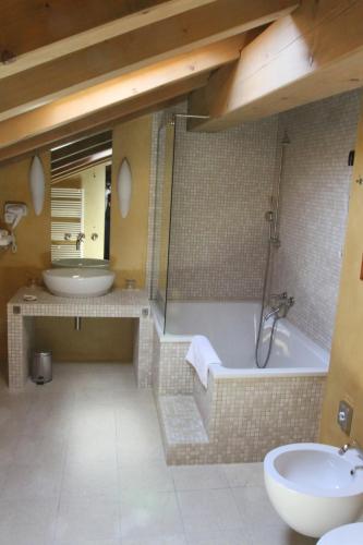 a bathroom with a tub and a sink and a toilet at Heritage Hotel Kukuriku in Kastav