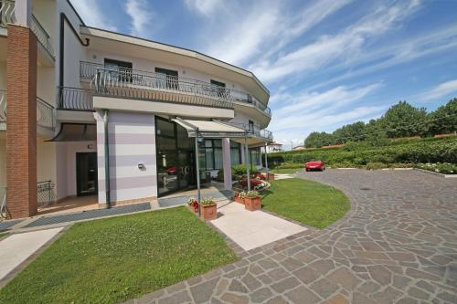 an apartment building with a patio and a driveway at Nettuno Residence Hotel in Peschiera del Garda
