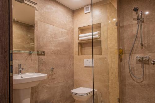 a bathroom with a shower and a toilet and a sink at Plaza Beach Holiday House in Prešov