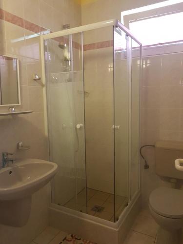 y baño con ducha, aseo y lavamanos. en Richie II. Apartman, en Siófok