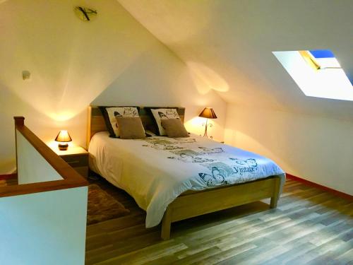 een slaapkamer met een bed en een dakraam bij Gîte L'Annexe in Crotenay