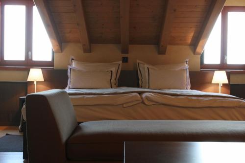 a bed in a room with two windows and a couch at Heritage Hotel Kukuriku in Kastav
